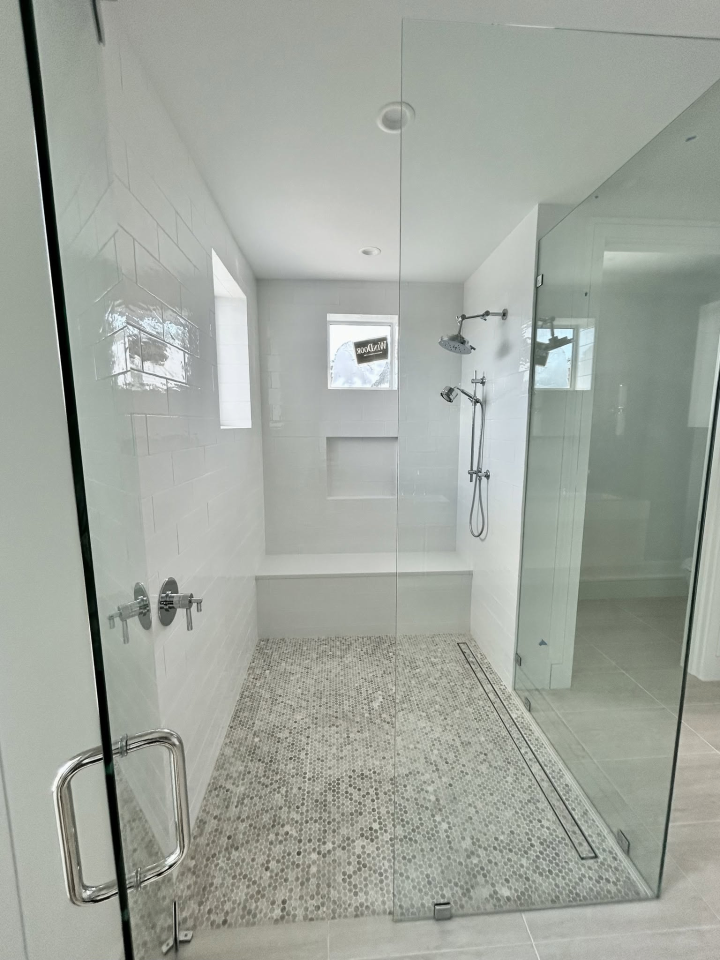 Walk-in shower with subway tile walls and marble penny mosaic floor