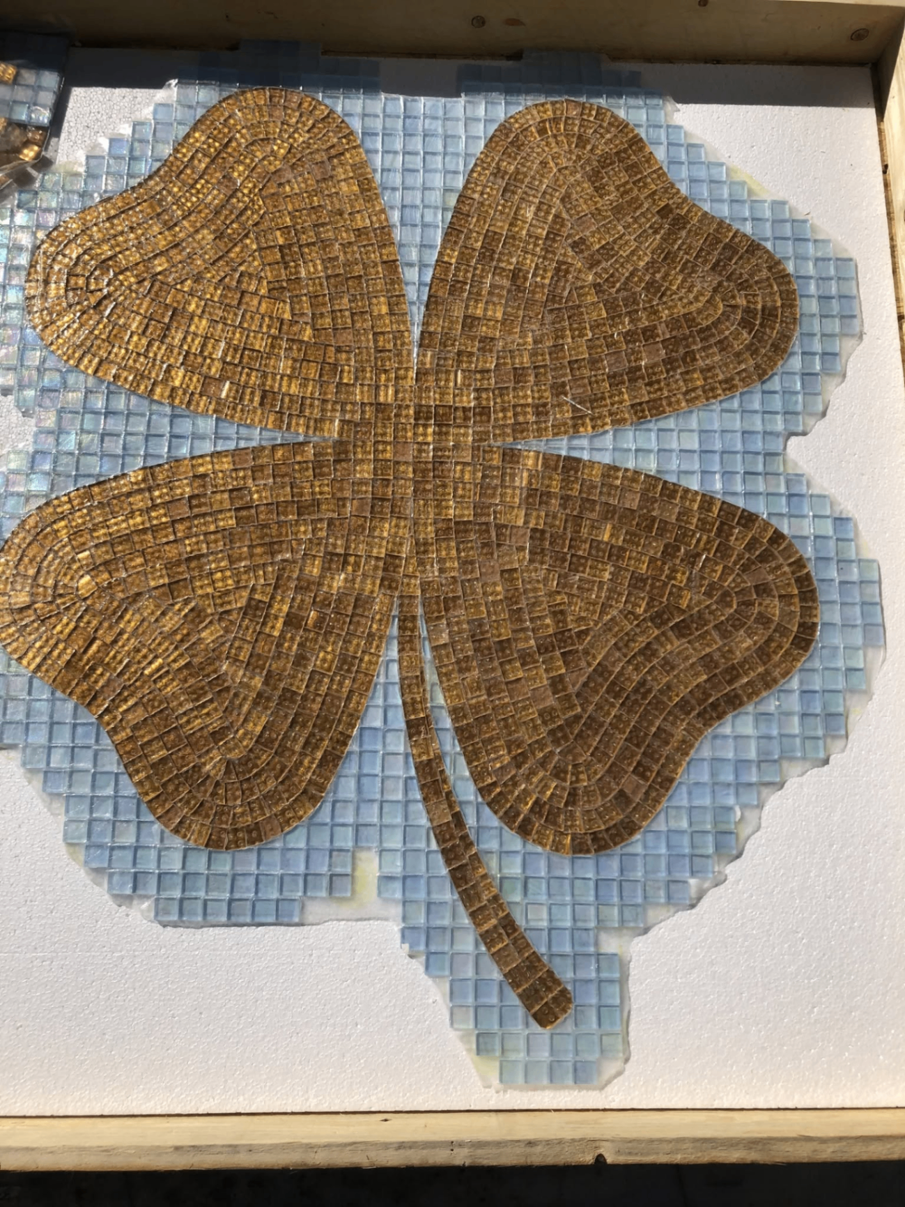 Hand-cut gold glass mosaic four-leaf clover medallion in progress